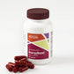 Maroon capsules sitting next to white bottle with maroon cap