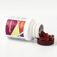 Maroon capsules sitting next to white bottle with maroon cap