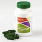 Green capsules sitting next to white bottle