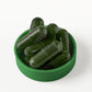 Green capsules sitting on bottle cap